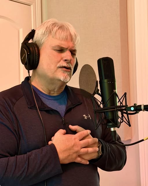 Wade singing into a studio microphone